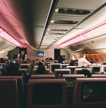 Interior view of a modern airplane cabin with passengers and flight attendants.